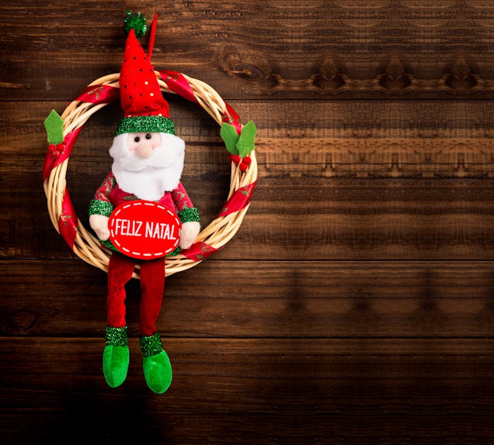 A festive wreath with a plush Santa Claus figure holding a red sign that says "Feliz Natal," hanging on a wooden wall.
