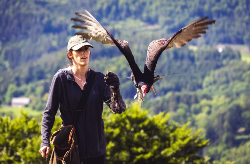 A woman with a bird flying in the air.