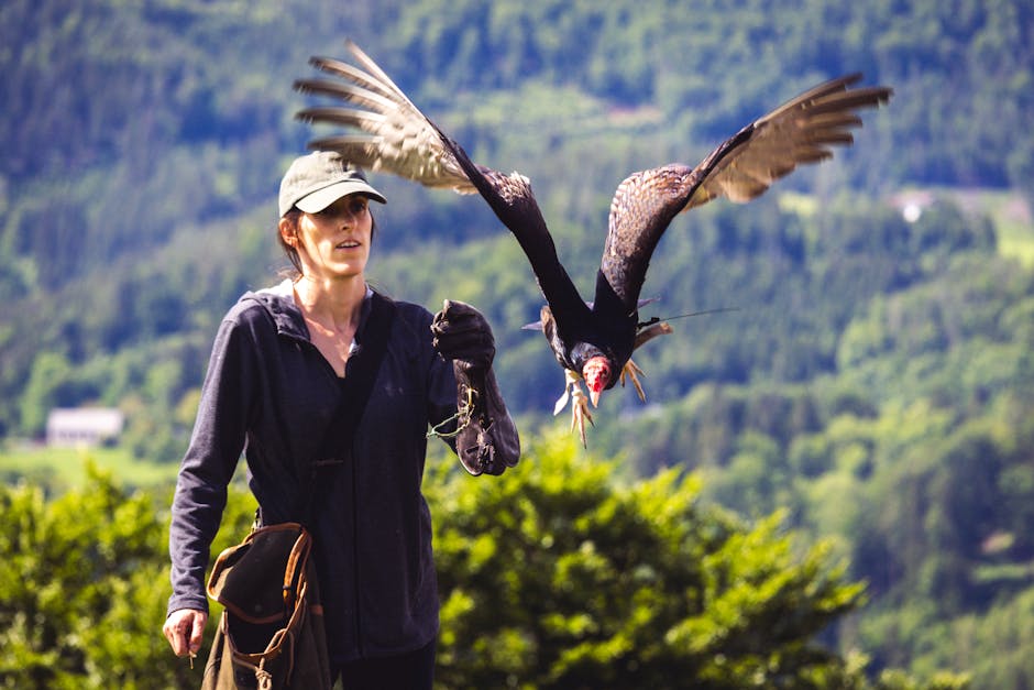 A woman with a bird flying in the air.