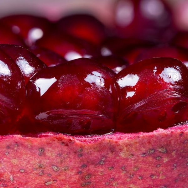 Close-up view of red pomegranate seeds clustered inside the fruit’s rind.