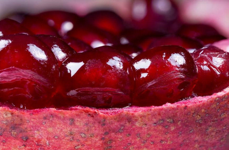 Close-up view of red pomegranate seeds clustered inside the fruit’s rind.