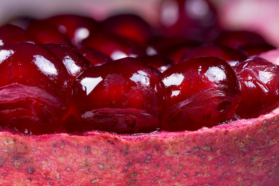 Close-up view of red pomegranate seeds clustered inside the fruit’s rind.